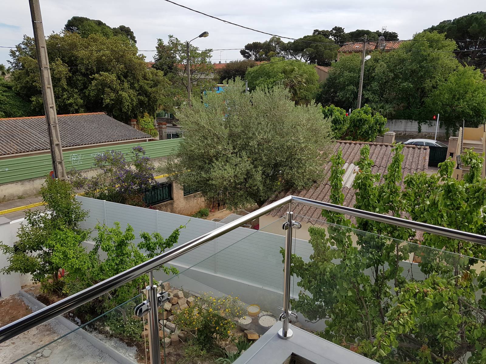 Rambarde en tube rond poli et verre entourant le balcon de la maison.
