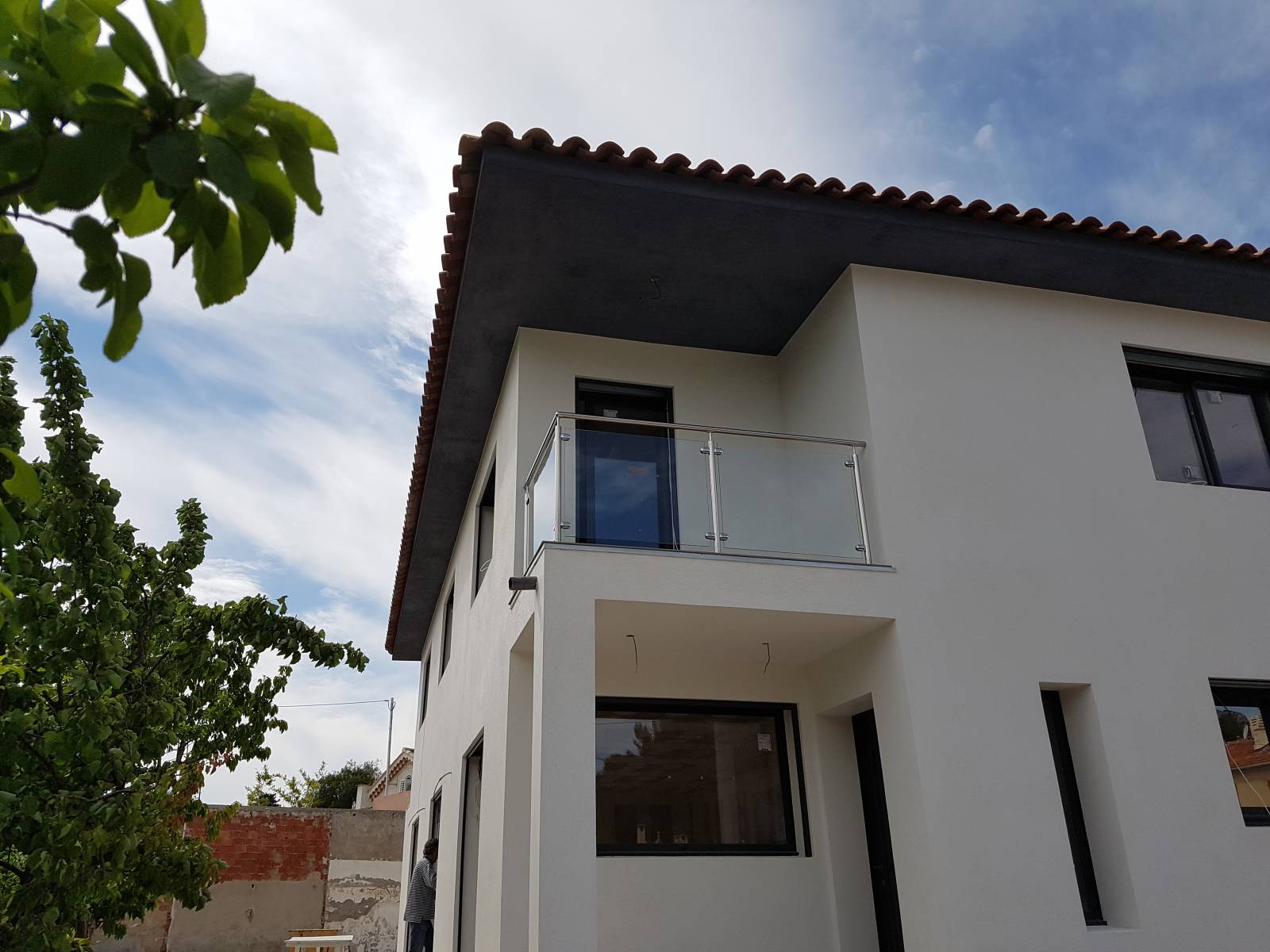 Vue panoramique de la maison et de la rambarde en inox, soulignant le design moderne de l'extérieur.