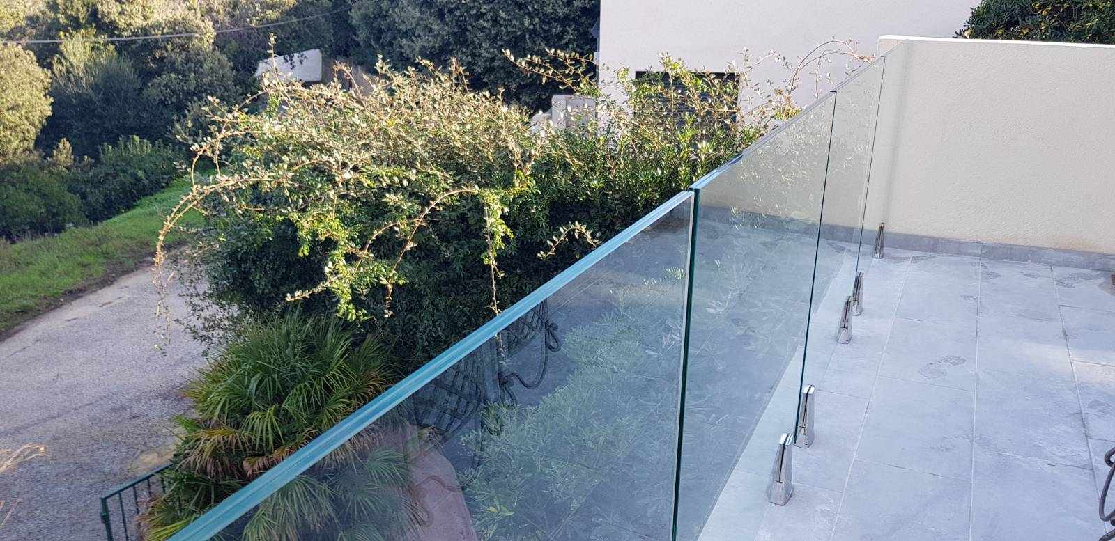 Garde-corps en verre trempé soutenu par des pinces en inox, offrant une vue dégagée et un design épuré.