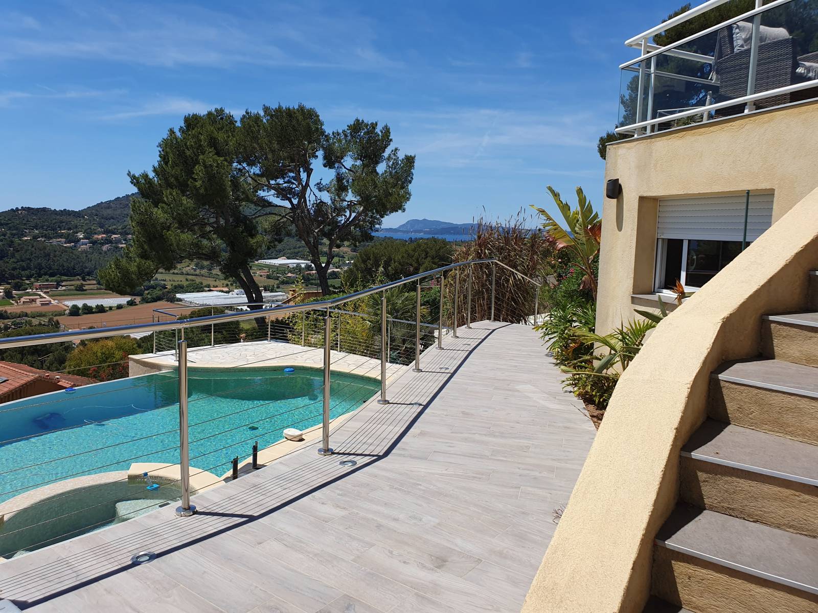 Garde-corps en inox entourant une terrasse à La Farlède, avec vue dégagée sur la piscine en contrebas.