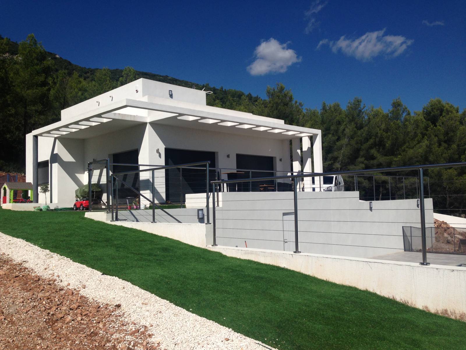 Garde-corps en inox et verre installé sur une terrasse à La Farlède, avec vue sur le jardin.