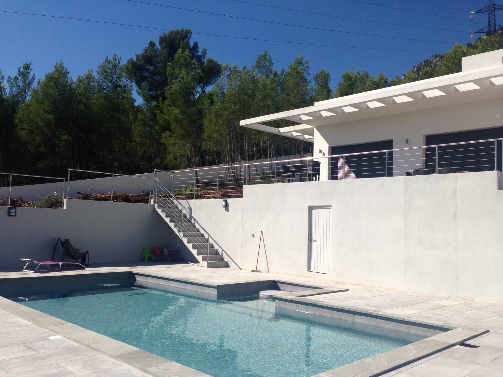 Vue d'ensemble d'une piscine à La Farlède, entourée d'un garde-corps en inox poli.