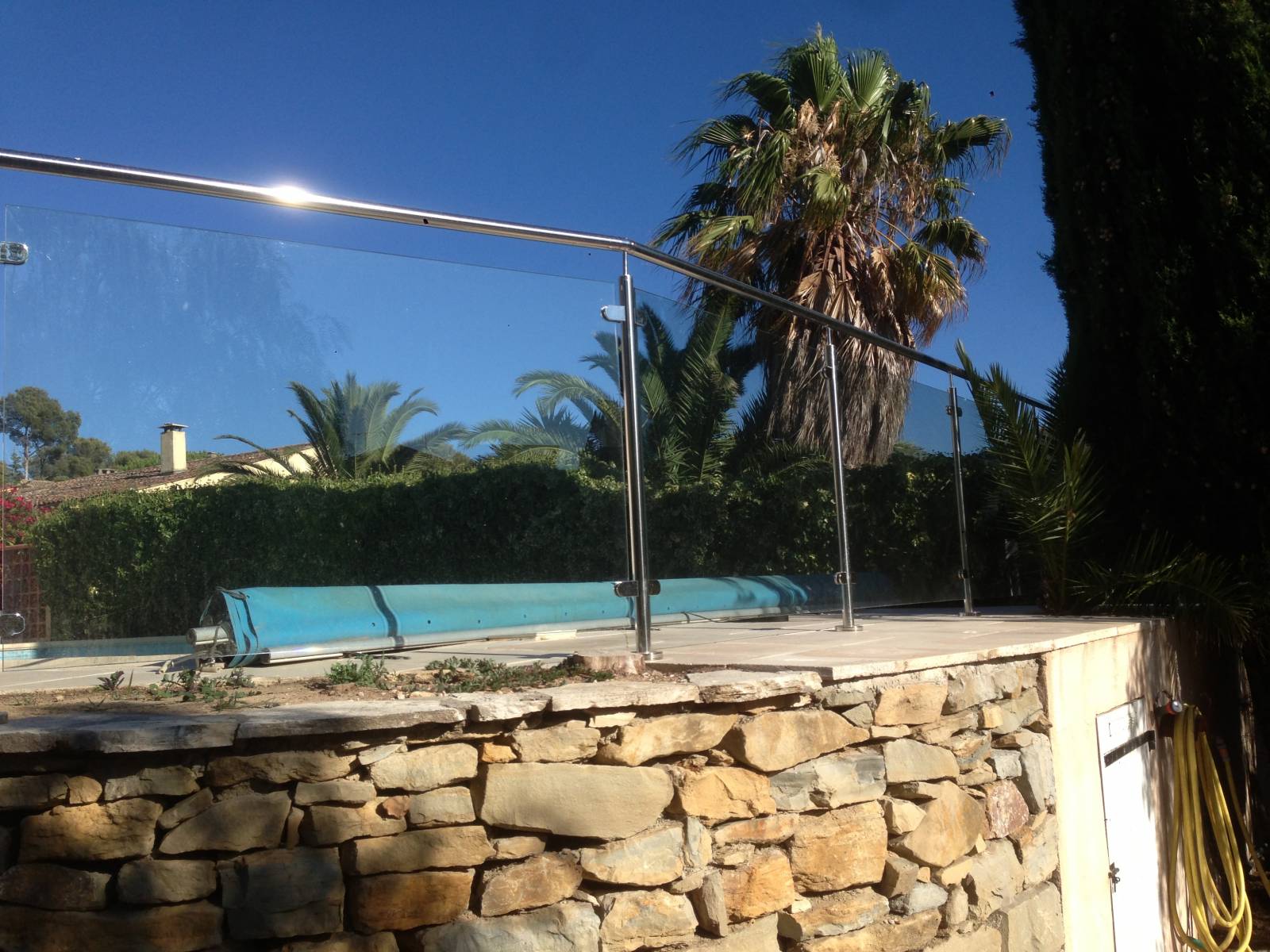 Détail d'une rambarde en inox et verre pour piscine, installée à Sanary, combinant sécurité et design contemporain.