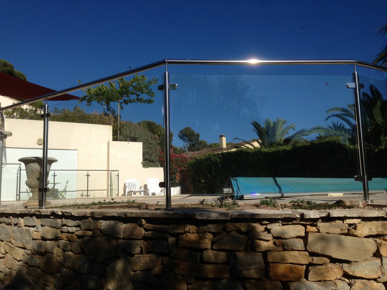 Rambarde en inox et verre autour d'une piscine à Sanary, offrant une vue dégagée tout en assurant la sécurité.