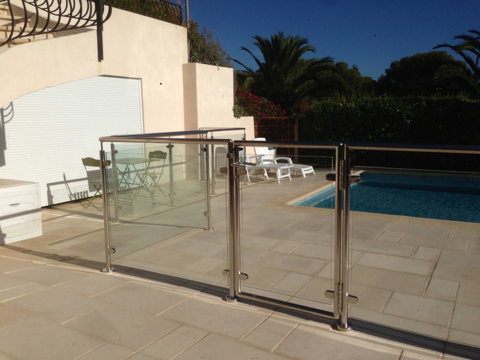 Piscine à Sanary sécurisée par une rambarde en inox et verre, alliant style moderne et fonctionnalité.