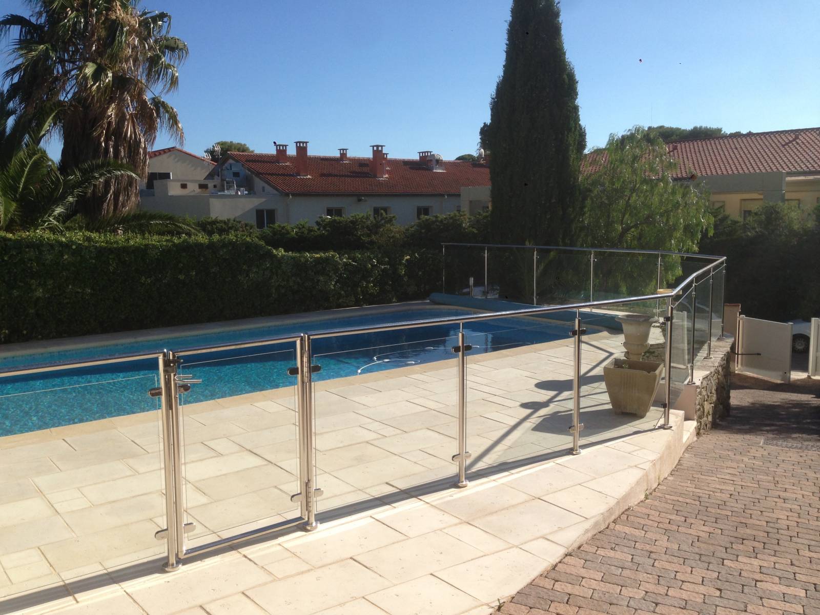 Rambarde en inox et verre autour d'une piscine à Sanary, offrant une vue dégagée tout en assurant la sécurité.