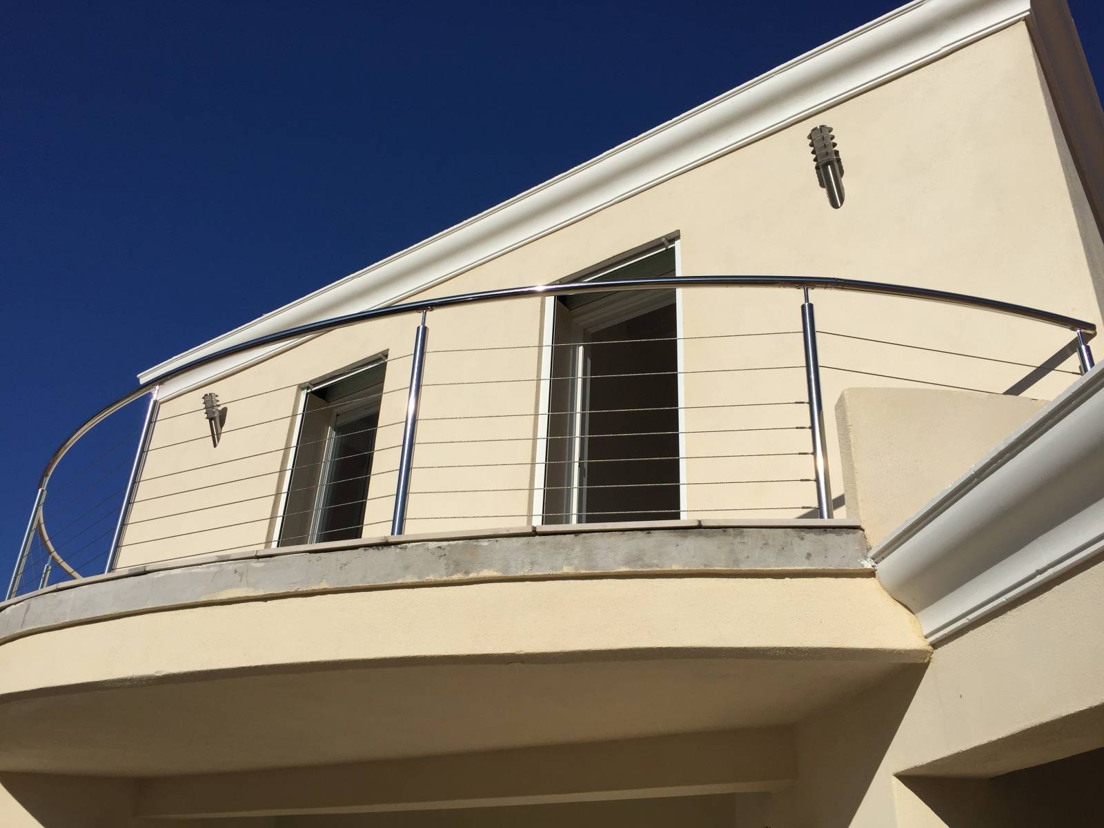 Installation de garde-corps en inox poli et câbles sur mesure pour balcon arrondi à Sanary