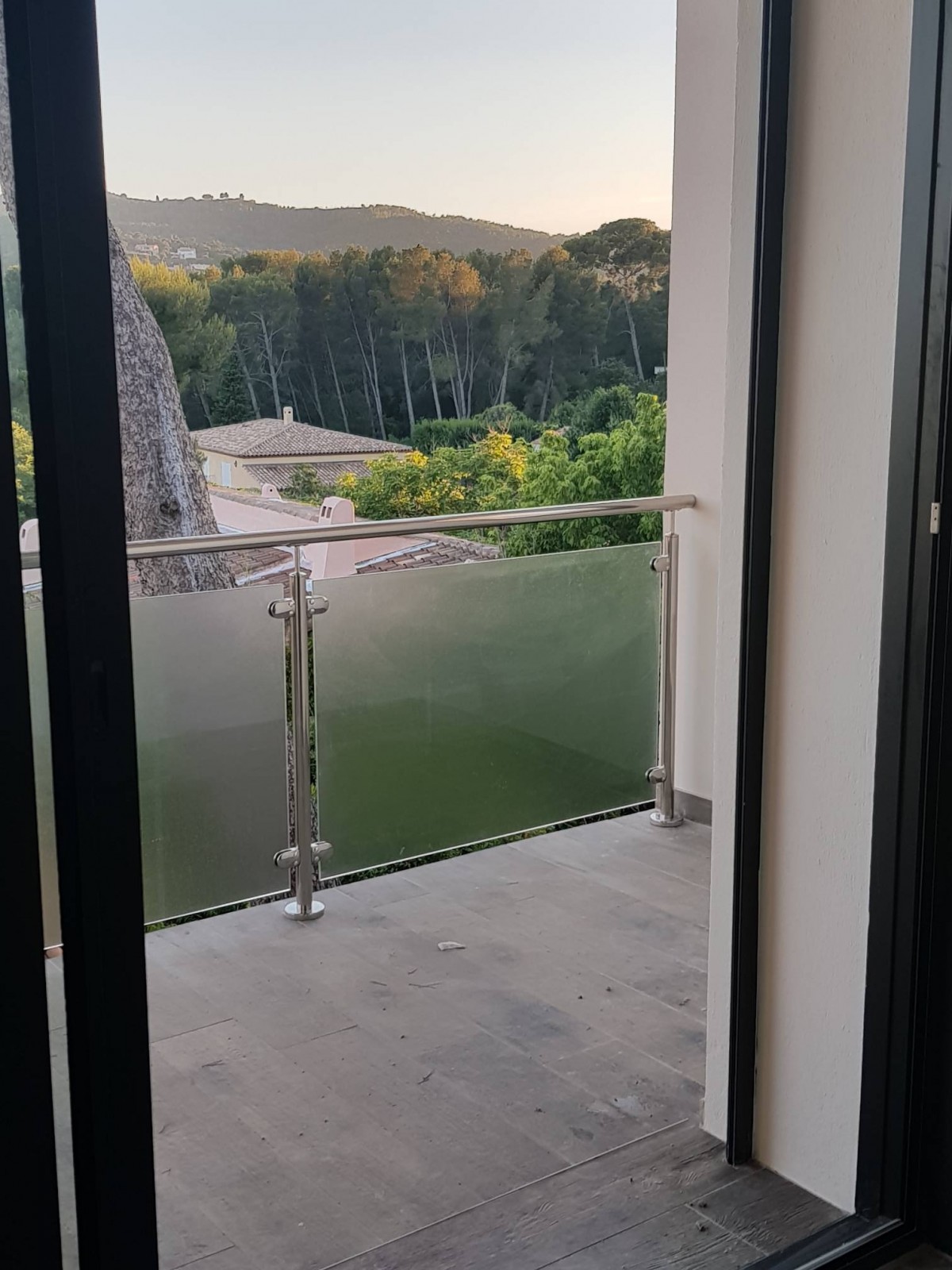Garde-corps en inox poli miroir avec verre imprimé, offrant une protection moderne et une intimité totale sur une terrasse en bord de mer.