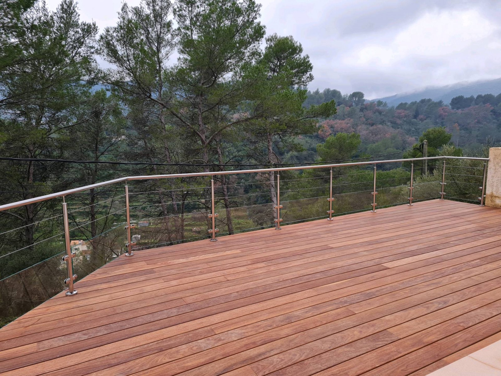 Terrasse moderne et sécurisée, mettant en valeur le design épuré de la rambarde en inox avec deux rangées de câbles.