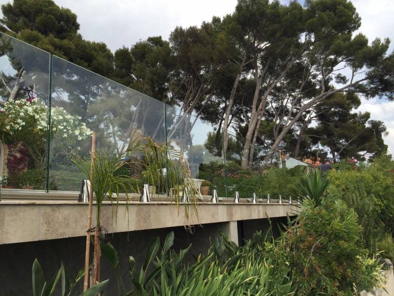 Installation de garde-corps en verre clair trempé avec pinces inox Poli 316L au bord de mer à Bandol