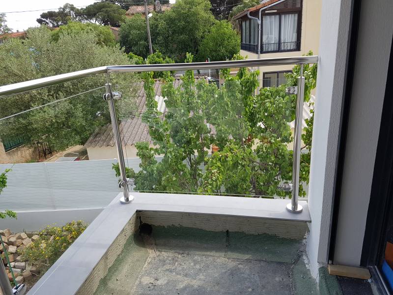 Détail de la façade de la maison avec rambarde en inox, offrant une touche d'élégance.