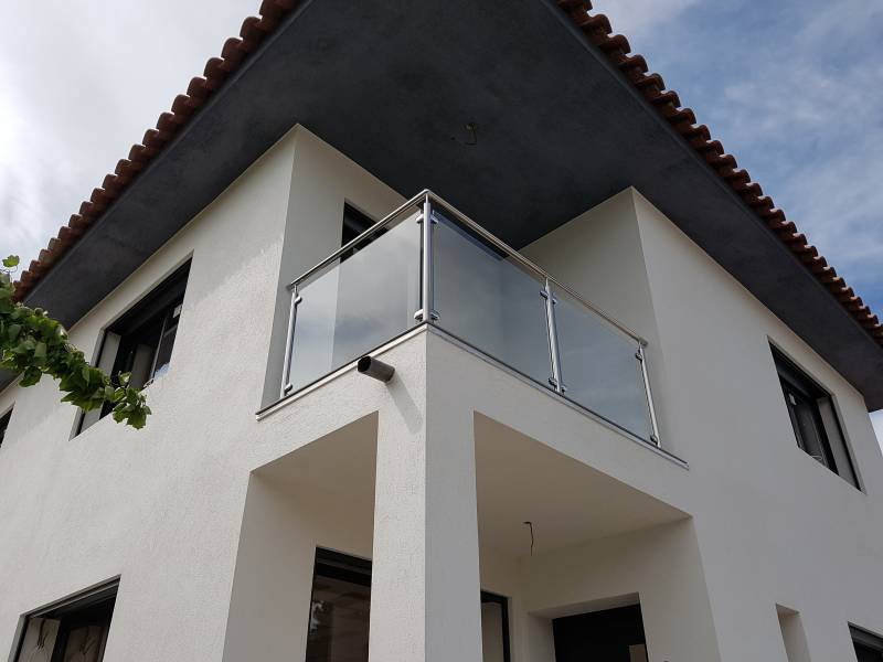 Vue panoramique de la maison et de la rambarde en inox, soulignant le design moderne de l'extérieur.