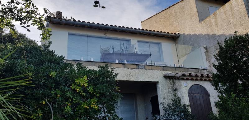 Vue d'un garde-corps en verre trempé fixé avec des pinces en inox, assurant une protection élégante.