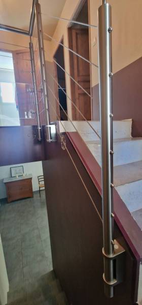 Fabrication d'une rampe et d'un garde-corps en inox brossé, câbles et verre pour des escaliers en intérieur