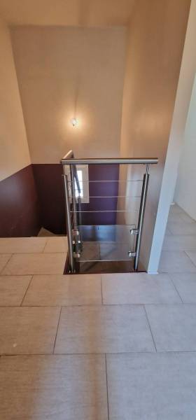 Fabrication d'une rampe et d'un garde-corps en inox brossé, câbles et verre pour des escaliers en intérieur