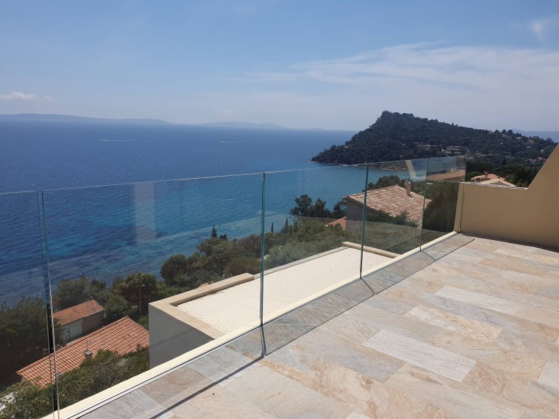 Vue panoramique d'une maison au Lavandou, mettant en valeur un garde-corps en verre avec rail encastré.