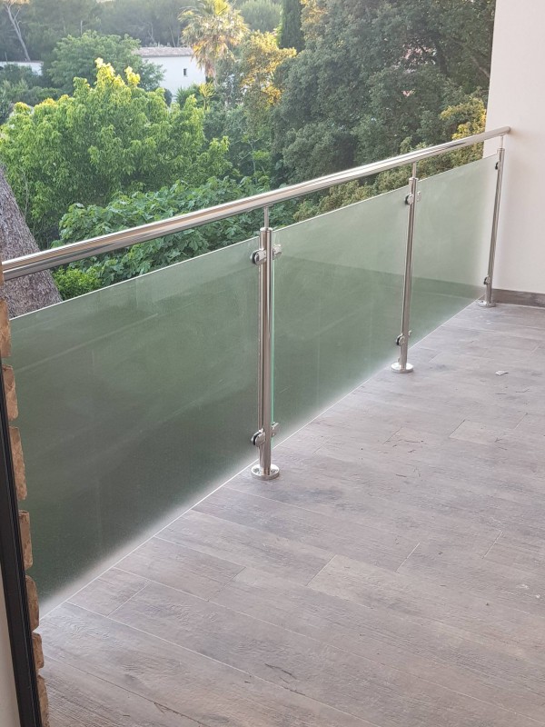 Détail du verre imprimé utilisé pour le garde-corps, laissant passer la lumière tout en agissant comme un brise-vue élégant.