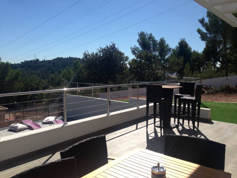 Photo d'un garde-corps en inox installé sur une terrasse à La Farlède, offrant un design moderne avec une vue sur le mobilier de terrasse