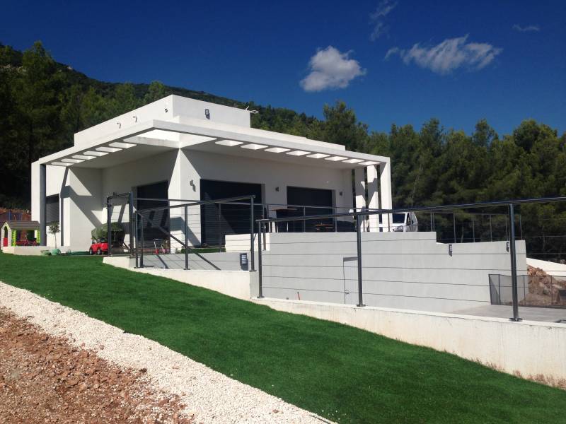 Garde-corps en inox et verre installé sur une terrasse à La Farlède, avec vue sur le jardin.