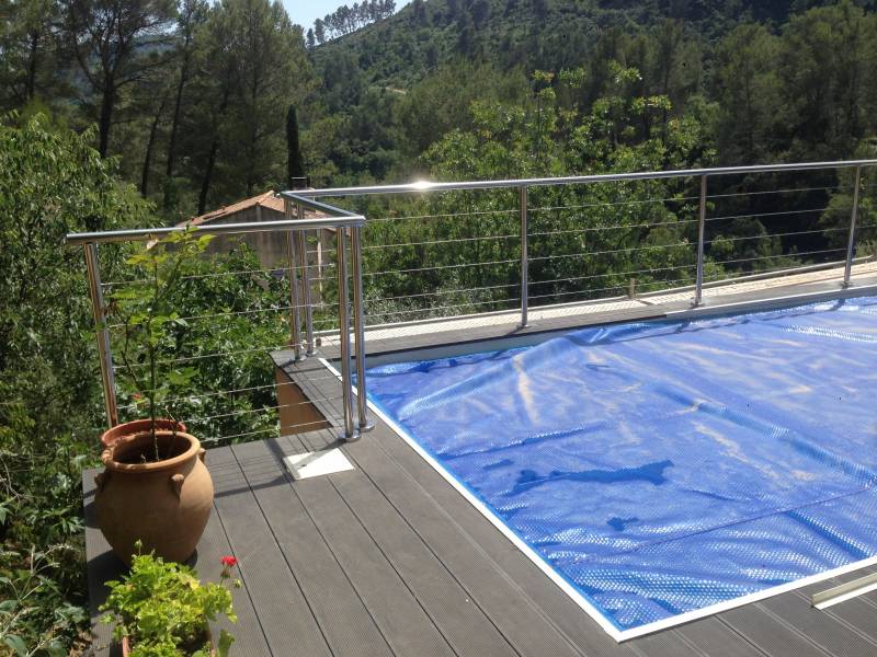 Rambarde en inox avec vue sur la piscine, installée autour d'une terrasse.
