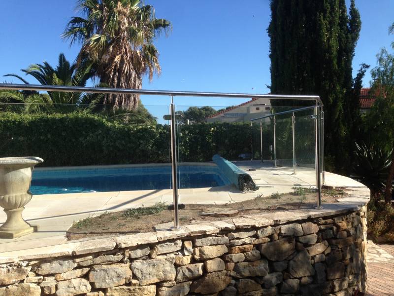 Détail d'une rambarde en inox et verre pour piscine, installée à Sanary, combinant sécurité et design contemporain.