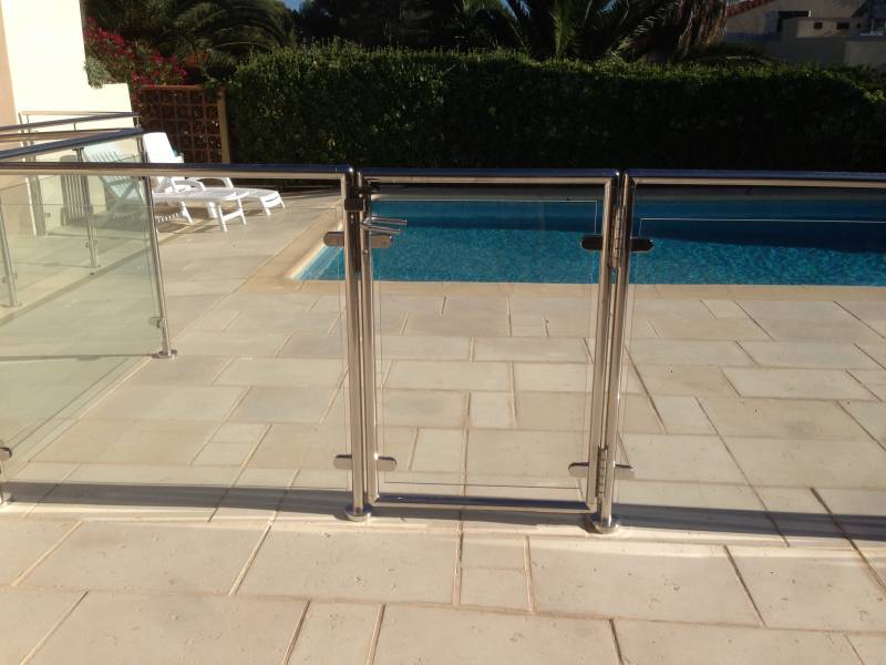 Installation de rambarde en inox et verre autour d'une piscine à Sanary, avec une vue dégagée sur l'eau.