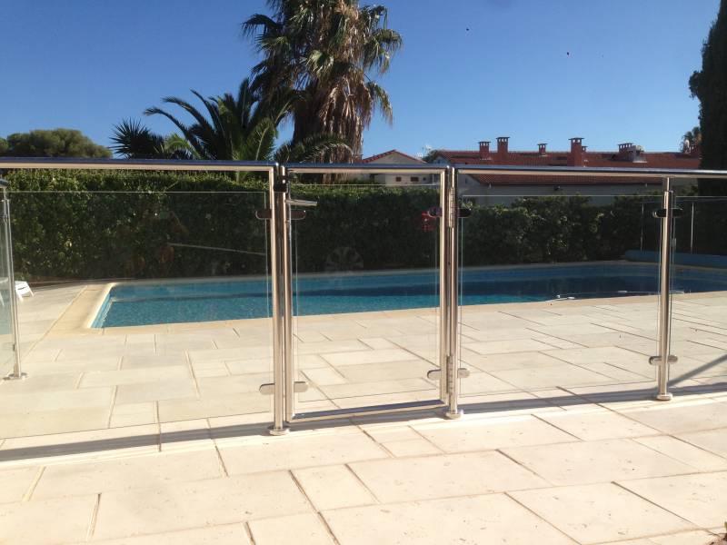 Installation de rambarde en inox et verre autour d'une piscine à Sanary, avec une vue dégagée sur l'eau.