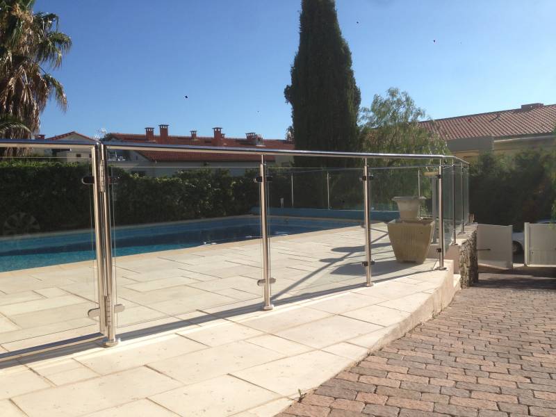 Piscine à Sanary sécurisée par une rambarde en inox et verre, alliant style moderne et fonctionnalité.