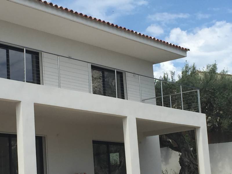 Maison avec rambarde en inox, offrant une protection et un design moderne.