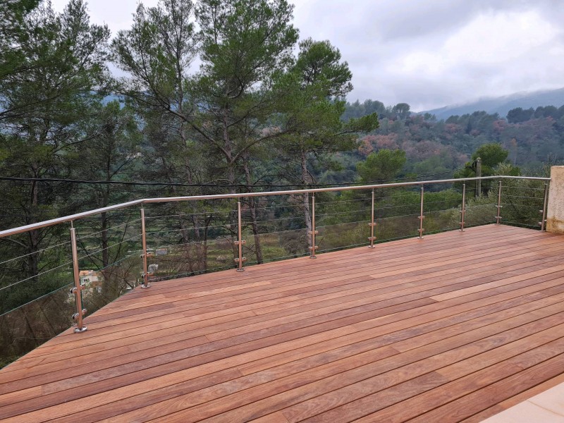 Terrasse moderne et sécurisée, mettant en valeur le design épuré de la rambarde en inox avec deux rangées de câbles.